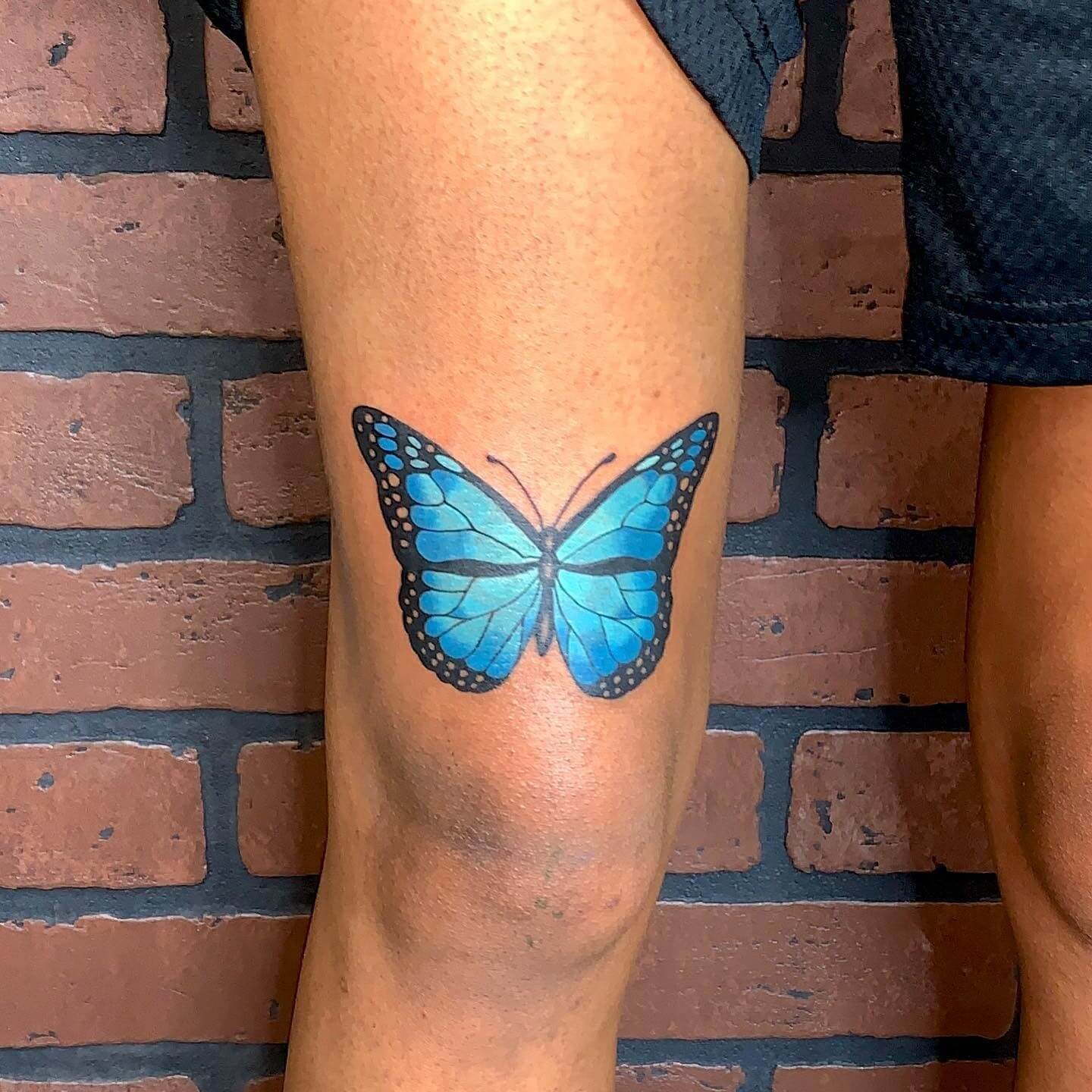 blue butterfly tattoo on leg