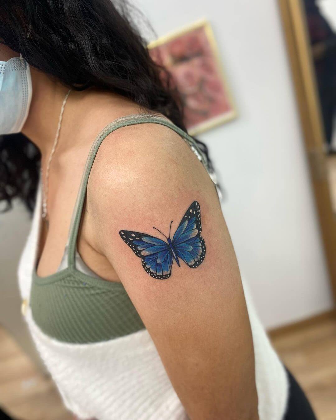 blue butterfly tattoo on shoulder