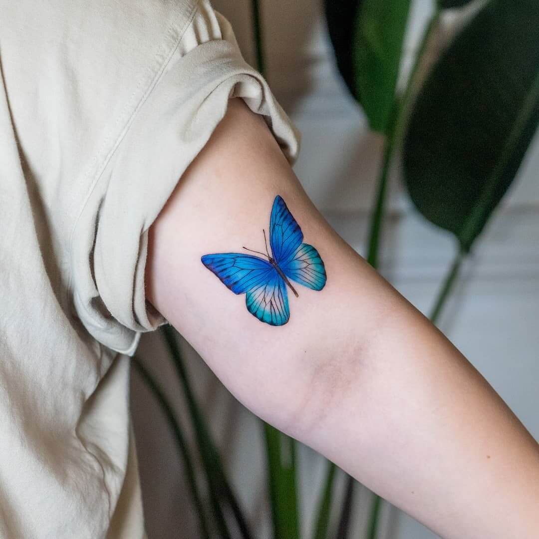 Blue butterfly arm tattoo