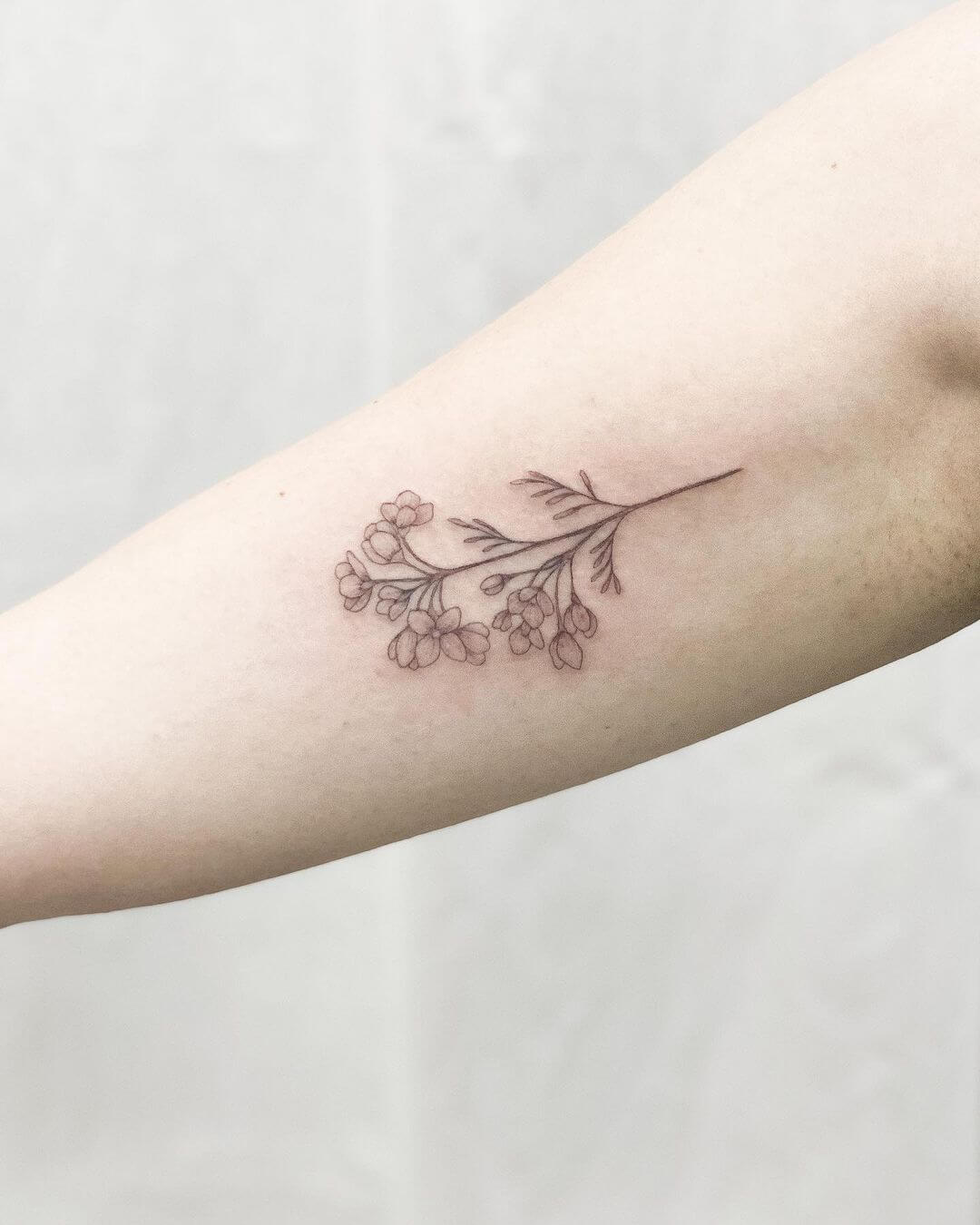 delicate fine line flower tattoo.